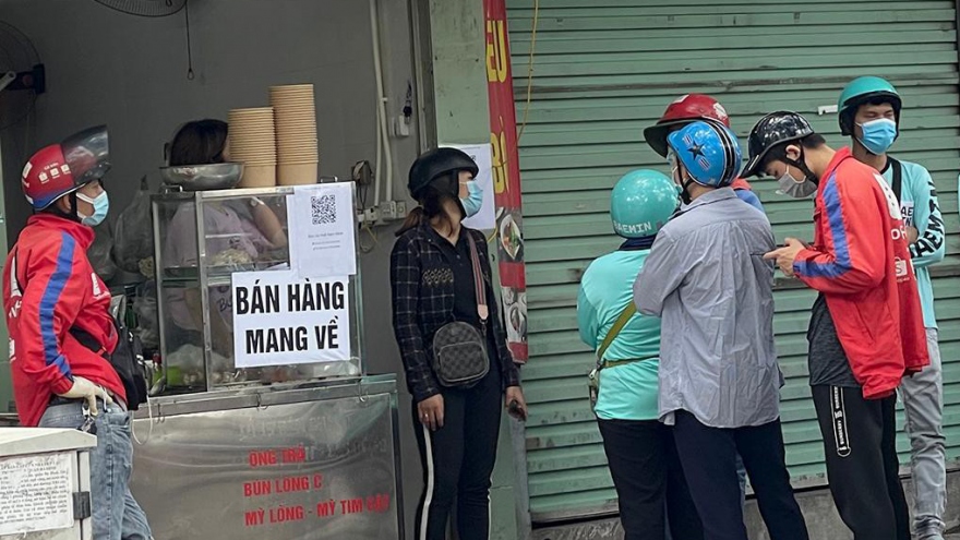 Locals apply pandemic counter measures at eateries in Hanoi