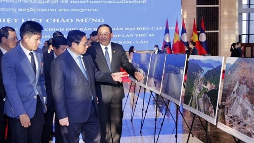 PMs of Vietnam, Laos visit photo exhibition on achievements of economic ties