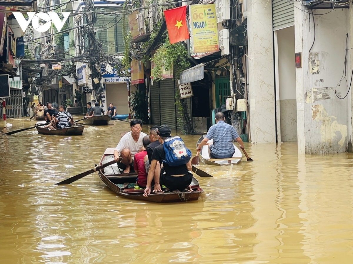 As floodwaters rise, Hanoians use boats for transportation, daily activities