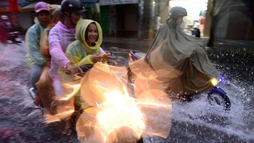 HCM City people wading through flood water on first working day